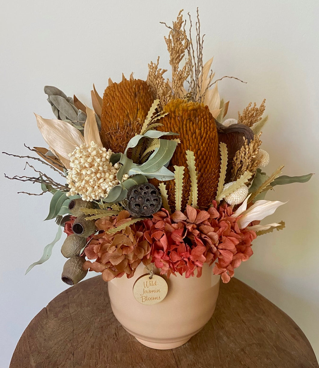 Orange Brush is created using dried, preserved and faux flowers and displayed in an apricot ceramic pot. 'It's burnt colour tones of orange, brown, green and white will add a statement to any room in the home or office. Approx size is 35cm x 25cm including pot. Sutherland Shire delivery. Sydney wide delivery. Australia wide delivery.