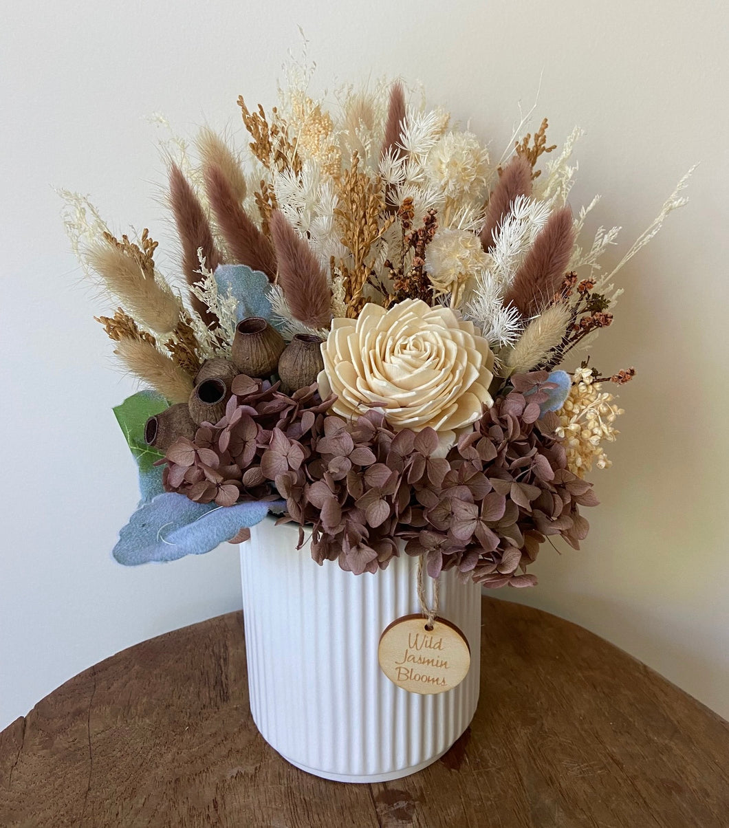 Chocolatte is created using dried, preserved and faux flowers and displayed in a ribbed ceramic pot. It's natural tones of cream, coffee and browns will add a boho vibe to any room in the home or office or is the perfect size for Nursing Homes and Hospitals. Approx size is 30cm x 20cm including pot. Sutherland Shire Delivery. Sydney Delivery. Australia wide delivery.