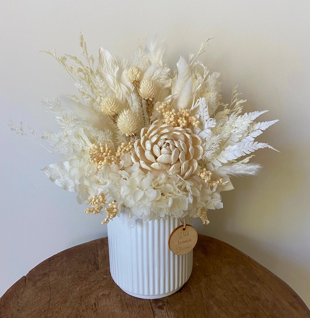 Lemonade is created using dried, preserved and faux flowers and displayed in a ribbed ceramic pot. It's neutral tones of cream and white will add a boho vibe to any room in the home or office or is the perfect size for Nursing Homes and Hospitals. Approx size is 30cm x 20cm including pot. Sutherland shire delivery. Sydney wide delivery. Australia wide delivery.