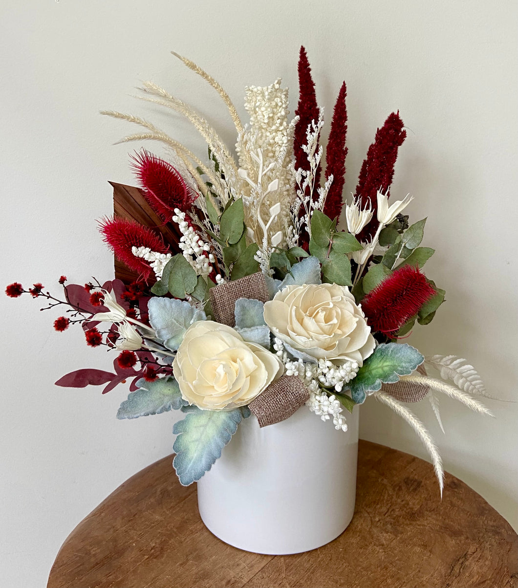 Scarlet is created using dried, preserved and faux flowers and displayed in a white ceramic pot. Perfect for the lovers of red! Approx size is 35cm x 30cm. Sutherland Shire delivery. Sydney delivery. Australia wide delivery.