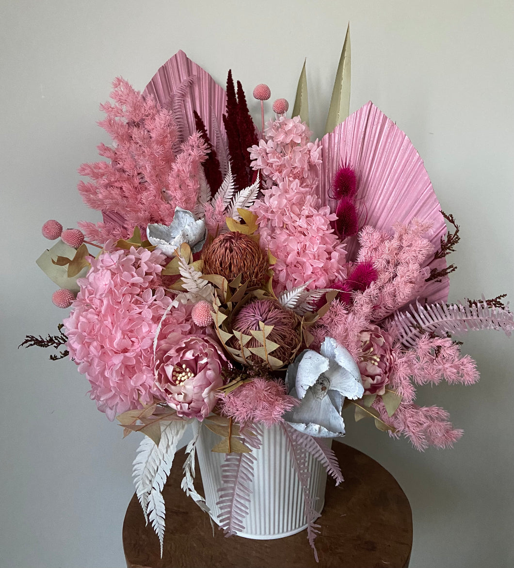 Pink Panther is created using dried, preserved and faux flowers and is displayed in a white ribbed tin bucket. This is a large arrangement in pinks with a touch of white and would look perfect in any pretty styled home or office. Approx size is 60cm x 45cm including pot. Due to the size of this arrangement, delivery is only available within the Sutherland Shire. For deliveries outside this area please message me.