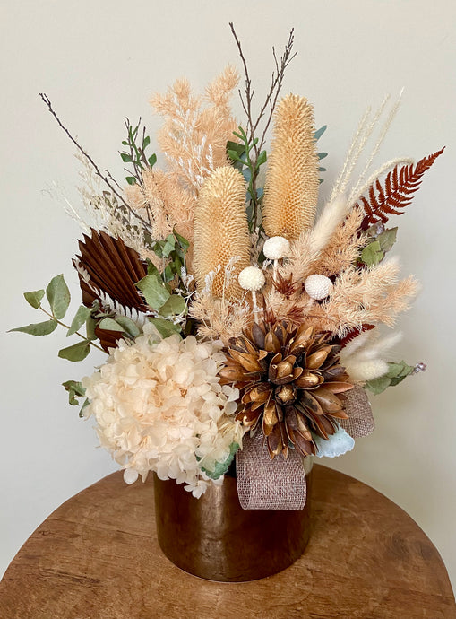 Golden Sun is created using dried, preserved and faux flowers and is displayed in a gold ceramic pot. Perfect display for a neutral home or office to bring a little warmth. Approx size is 40cm x 30cm including pot. Sutherland Shire Delivery. Sydney Delivery. Australia wide Delivery.
