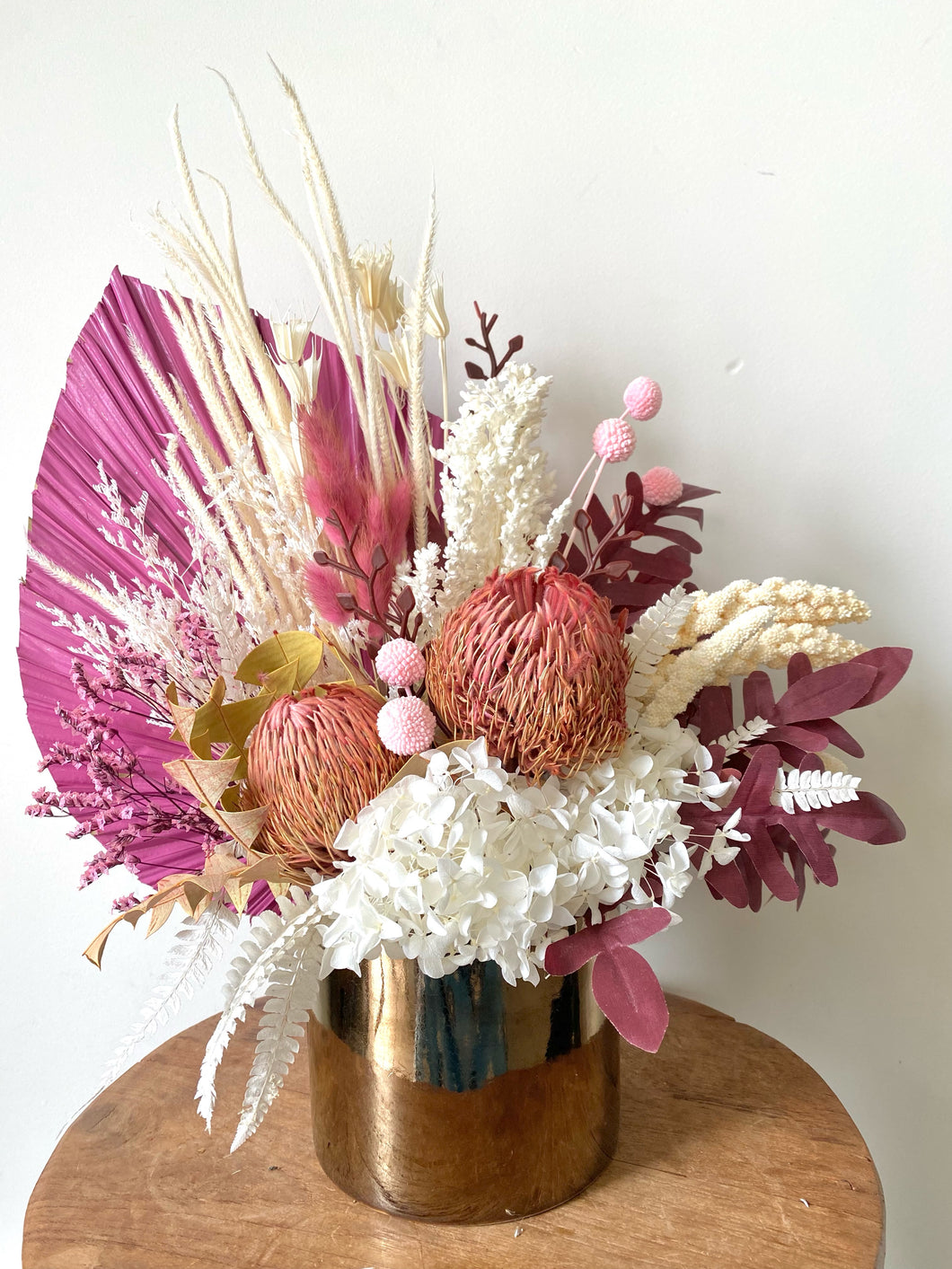 Dried Flowers. Posy dried. Dried flower arrangement.Dried flowers delivered Sutherland Shire. Dried flowers delivered Sydney. Dried flower gifts.Custom design flower arrangementsPink Passion dried, preserved and flower arrangement displayed in a gold ceramic pot. Its compact style makes a gorgeous side table display or a great nursing home or hospital display. Approx size is 40cm x 40cm. Dried flowers delivered Sutherland Shire. Dried flowers delivered Sydney. Dried arrangements custom made available. 