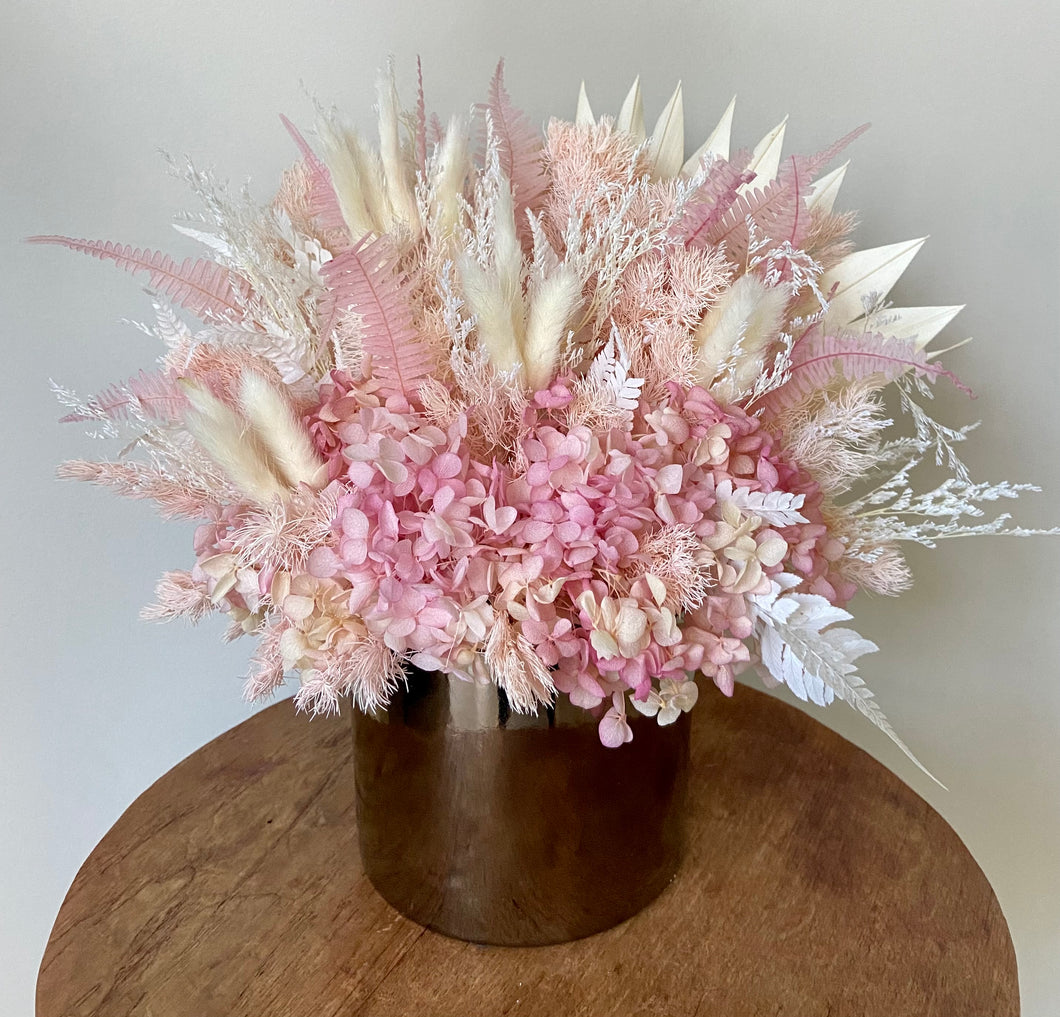 Strawberry Shortcake is a dried, preserved and faux flower arrangement displayed in a gold ceramic pot. Its simple blush style makes a gorgeous side table display for home, office or the perfect gift for a baby girl! Approx size is 30cm x 30cm including pot. Sutherland Shire Delivery. Sydney wide delivery. Australia wide delivery.