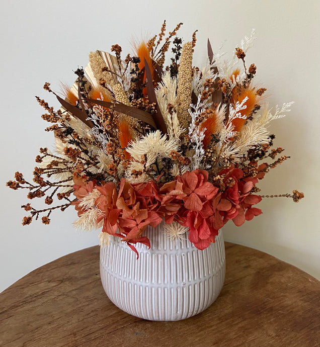 Burnt Brush is created using dried, preserved and faux flowers and displayed in a ribbed concrete pot. Beautiful warm burnt orange colours, a perfect mini arrangement. Great size for Nursing Homes and Hospitals too. Approx size is 25cm x 25cm including pot. Sutherland Shire delivery. Sydney wide delivery. Australia wide delivery.