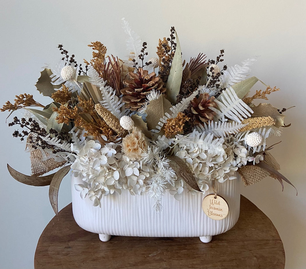 Bush Dance is created using dried, preserved and faux flowers and is displayed in a ribbed ceramic trough. This natural toned beauty will add warmth to any room or position and as its all rounded with flowers, it would make a perfect coffee table display. Approx size is 38cm x 30cm including pot. Sutherland Shire Delivery. Sydney Wide Delivery. Australia Wide Delivery.