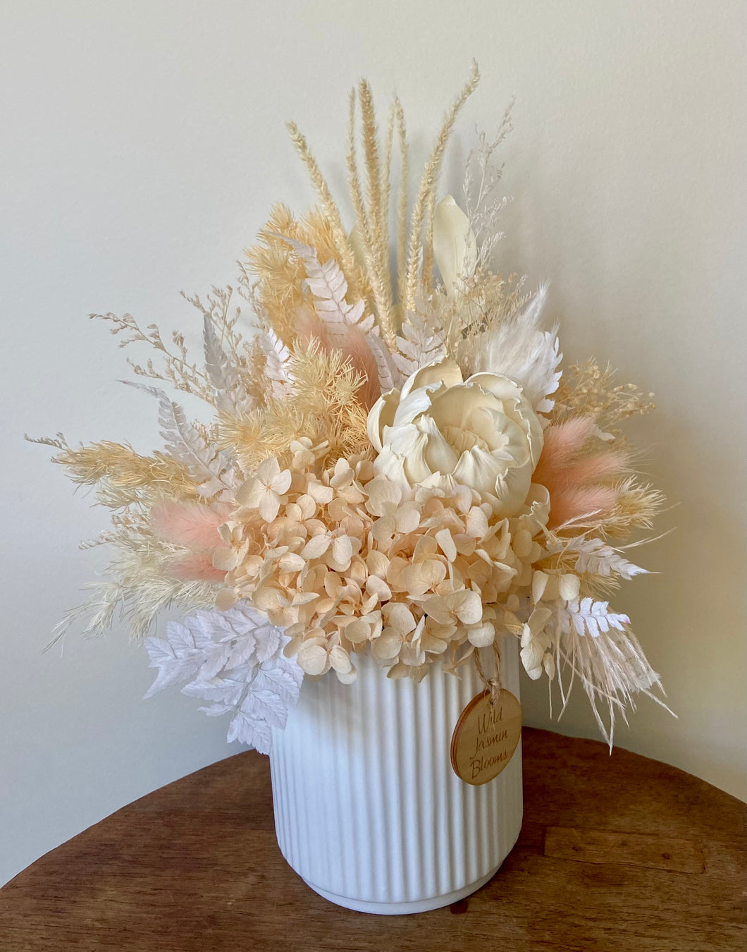 Apricot Dream is created using dried, preserved and faux flowers and displayed in a ribbed ceramic pot. It's dainty colours will add a boho vibe to any room in the home or office or is the perfect size for Nursing Homes and Hospitals. Approx size is 30cm x 25cm including pot. Sutherland Shire Delivery. Sydney wide delivery. Australia wide delivery.