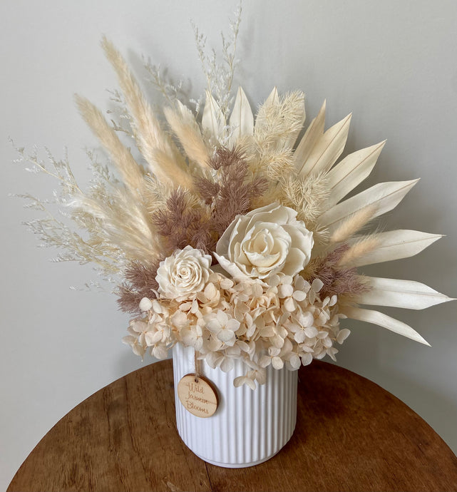 Cocoa Bliss is created using dried, preserved and faux flowers and displayed in a ribbed ceramic pot. It's neutral tones of cream and coffee will add a boho vibe to any room in the home or office or is the perfect size for Nursing Homes and Hospitals. Approx size is 30cm x 30cm including pot. Sutherland Shire delivery. Sydney wide delivery. Australia wide delivery.